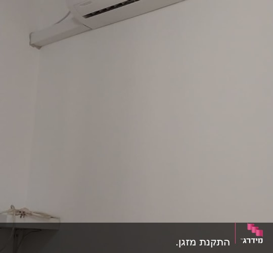 מזגן מותקן על קיר לבן בחדר